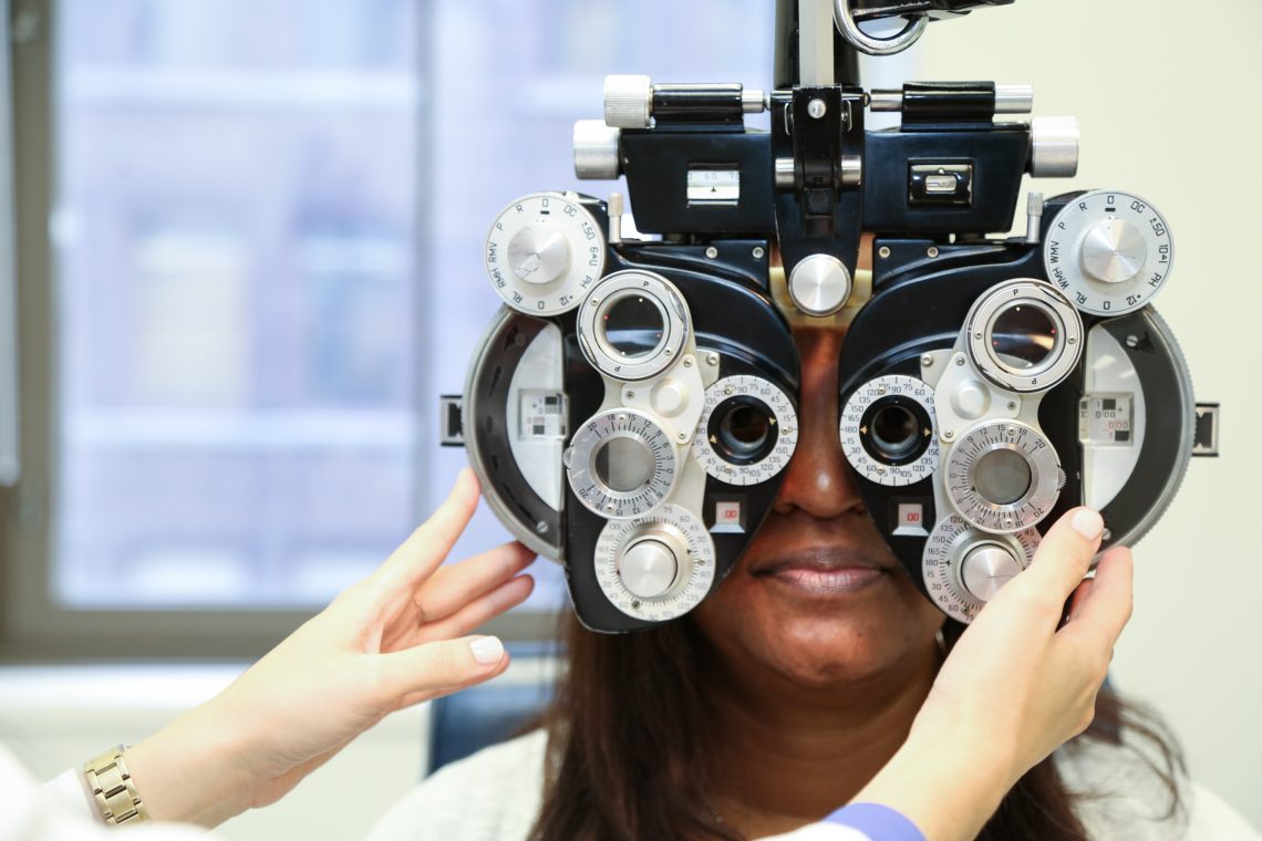 Patient looking throguh eye exam equipment