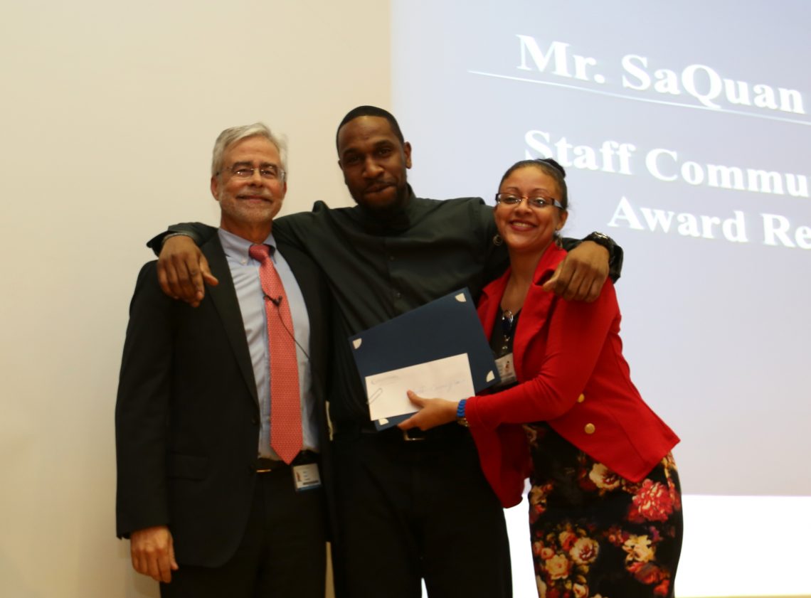 Staff receiving award in theater with Dr. David Heath