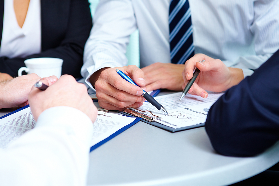 Image of human hands during discussion of business plan at meeting