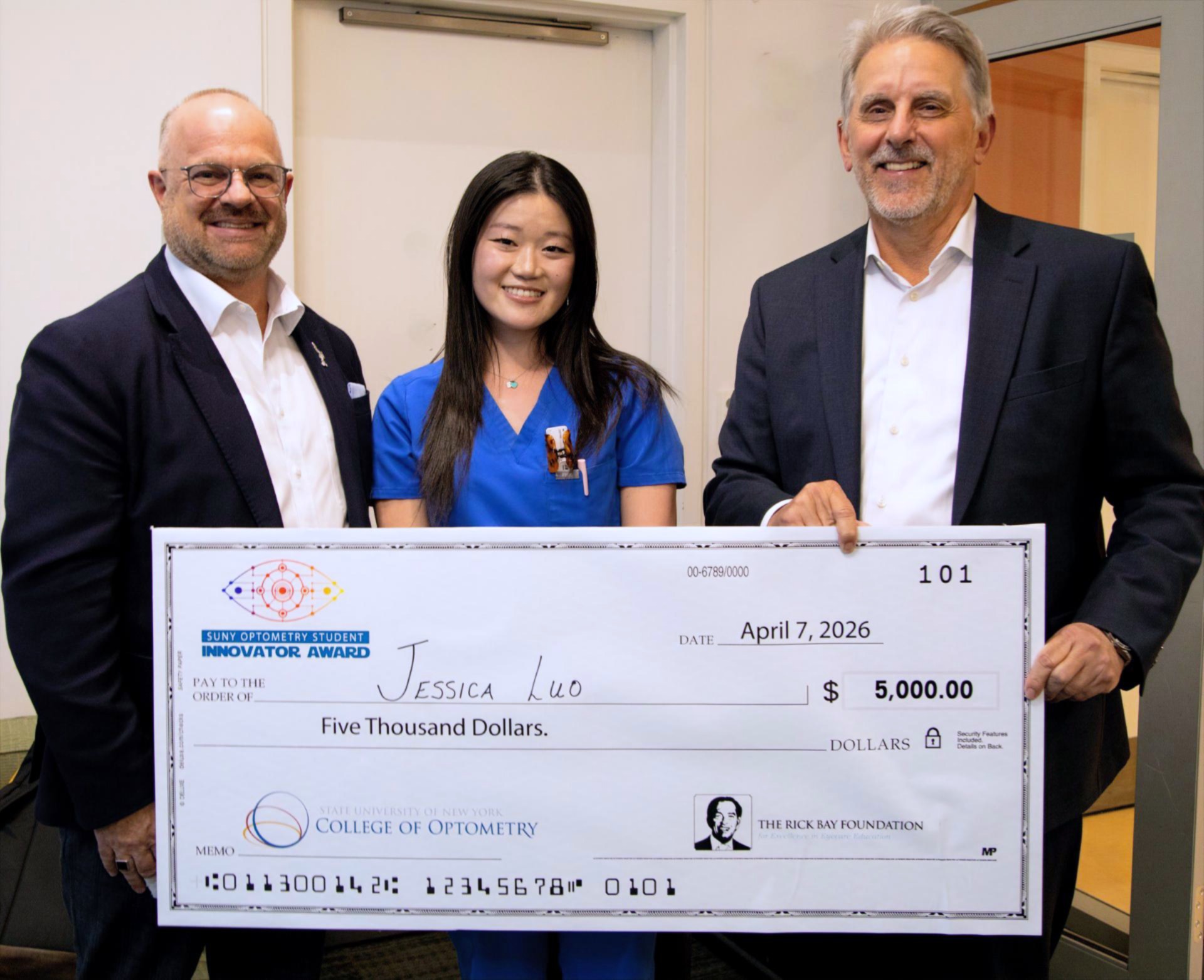 Group of three holding a $5,000 check