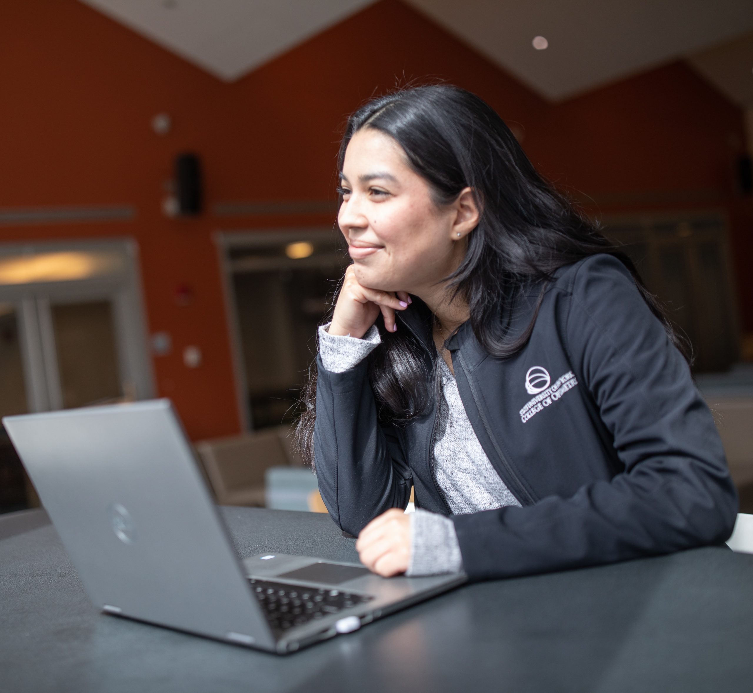Female student sitting with laptop.