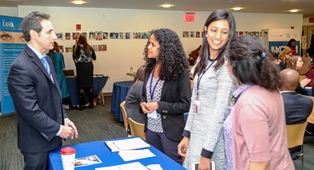 Participants speaking with a representative from one of the sponsors